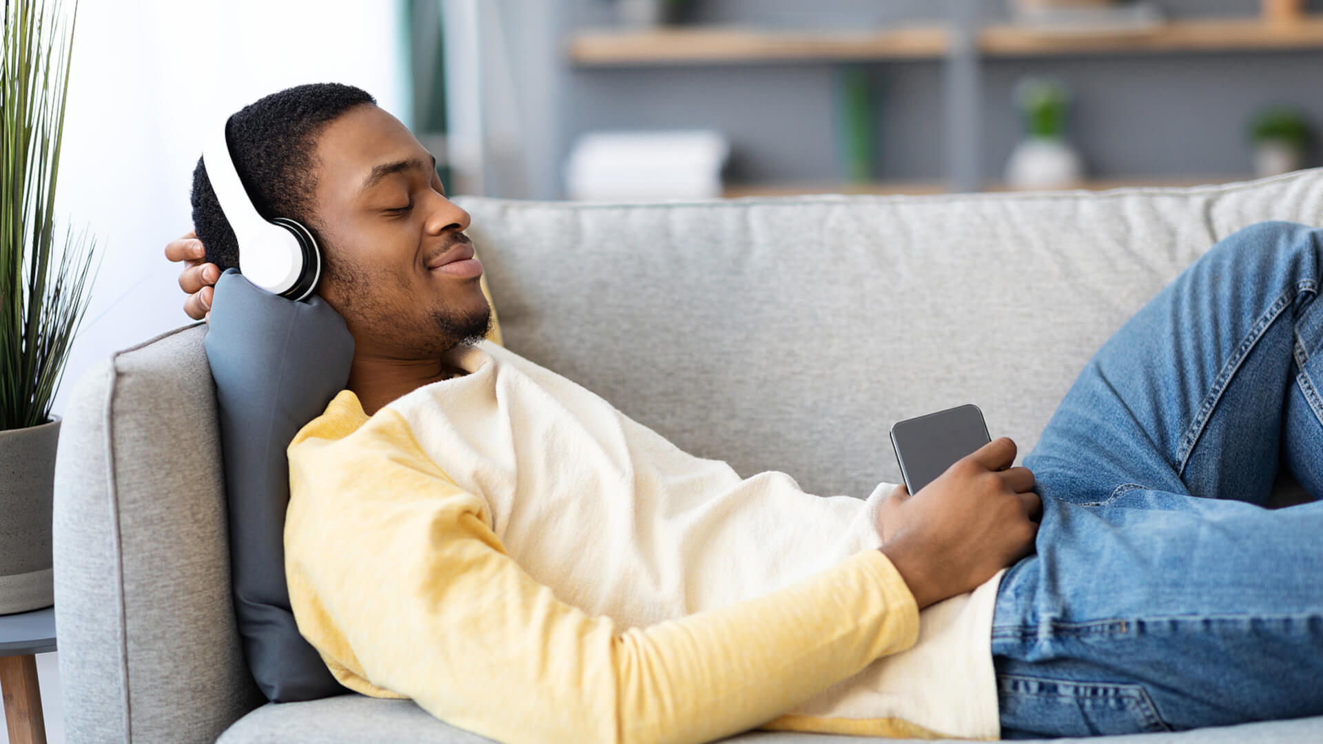 Man laying on couch listening to music