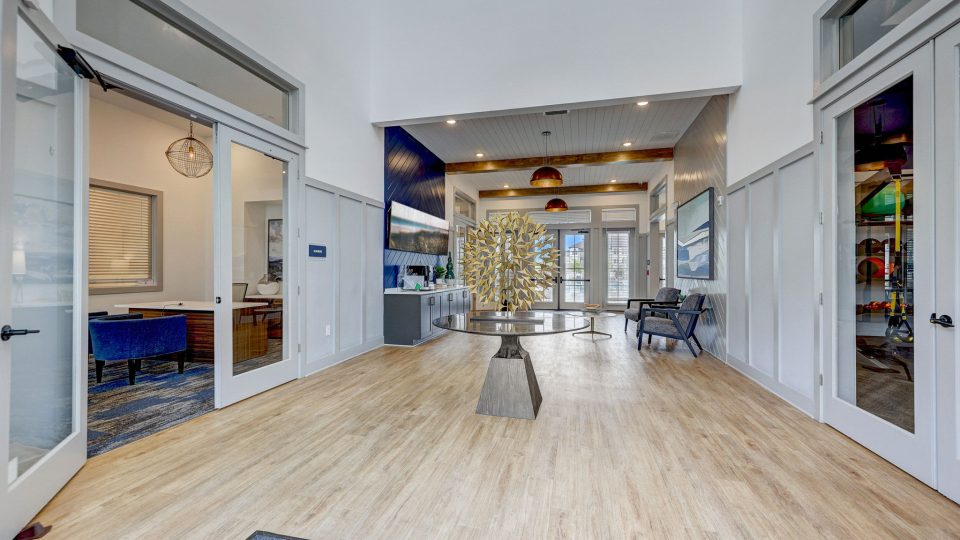 the lobby of a residential apartment building with hardwood floors at The Story Mundy Mill