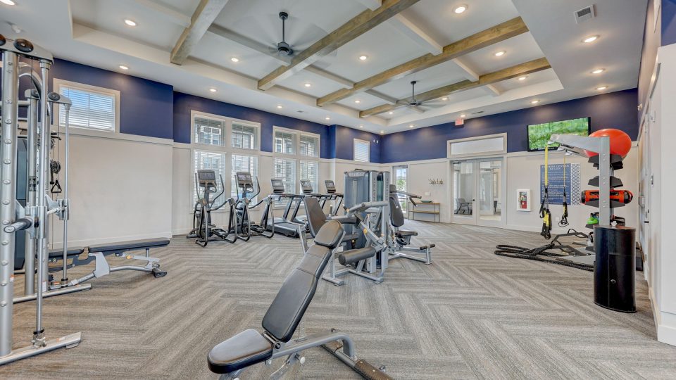 a gym room with equipment and blue walls at The Story Mundy Mill