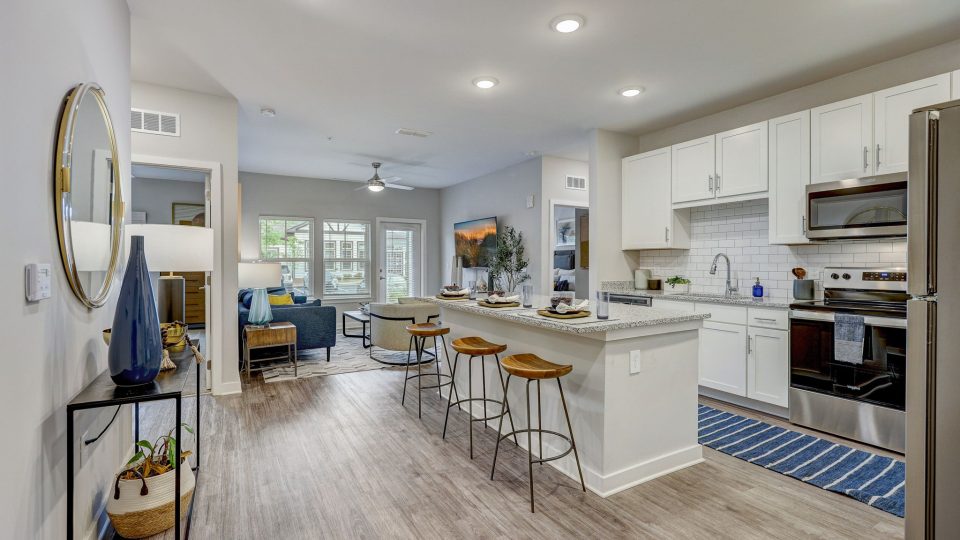 a kitchen with white cabinets and hardwood floors at The Story Mundy Mill