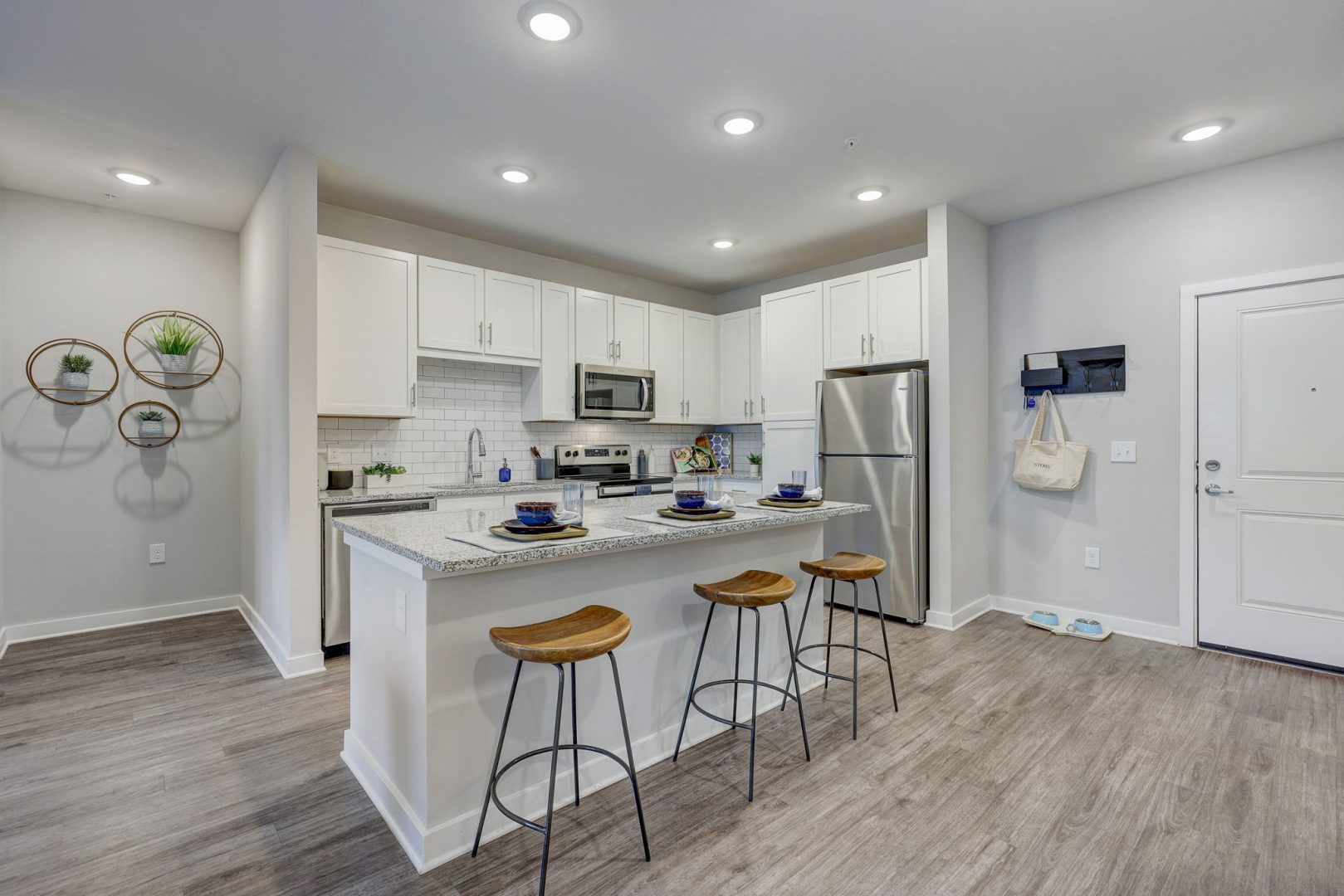 a clean and white kitchen with stainless steel appliances at The Story Mundy Mill